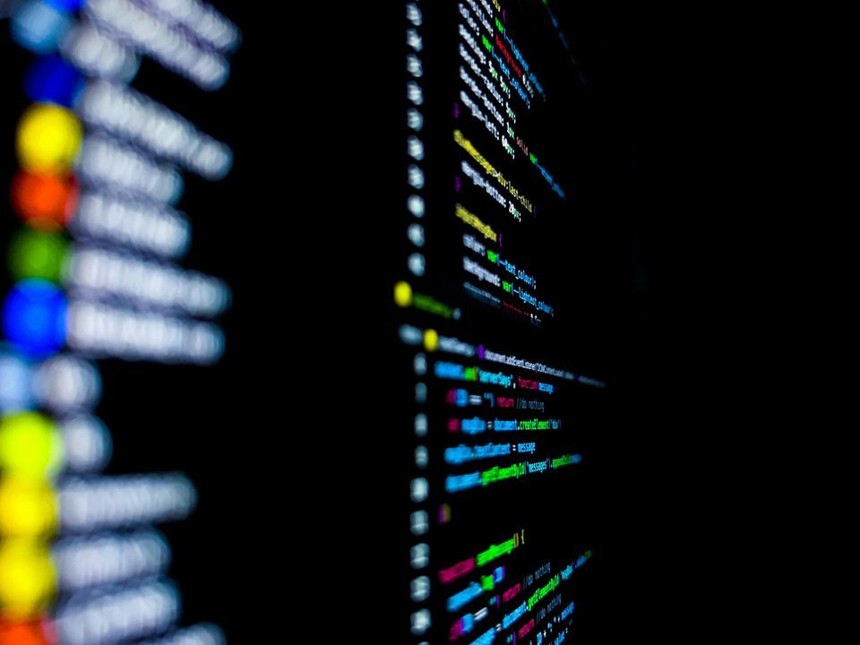 Colourful source code displayed on a dark monitor at a shallow angle