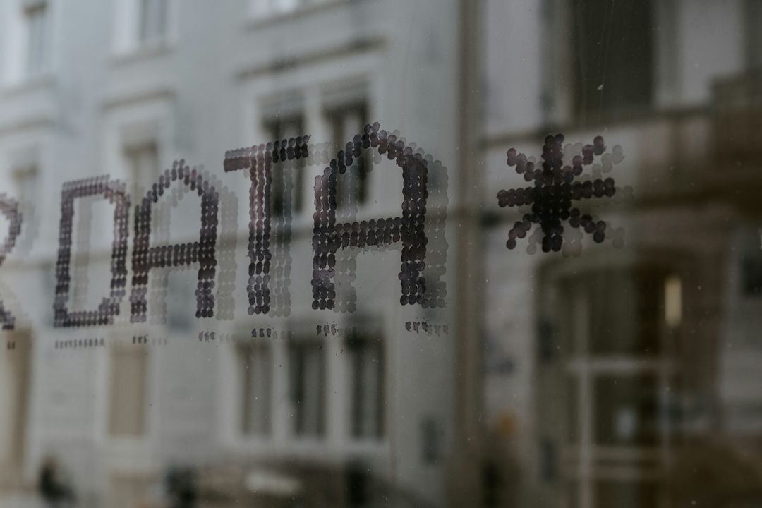 The word DATA spelled out in dots on a window, with a building reflected behind