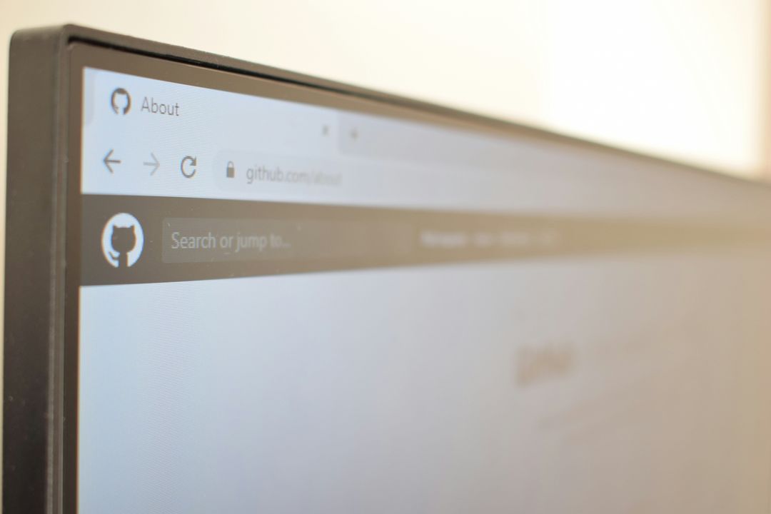 Corner of a monitor showing a browser open at github.com/about